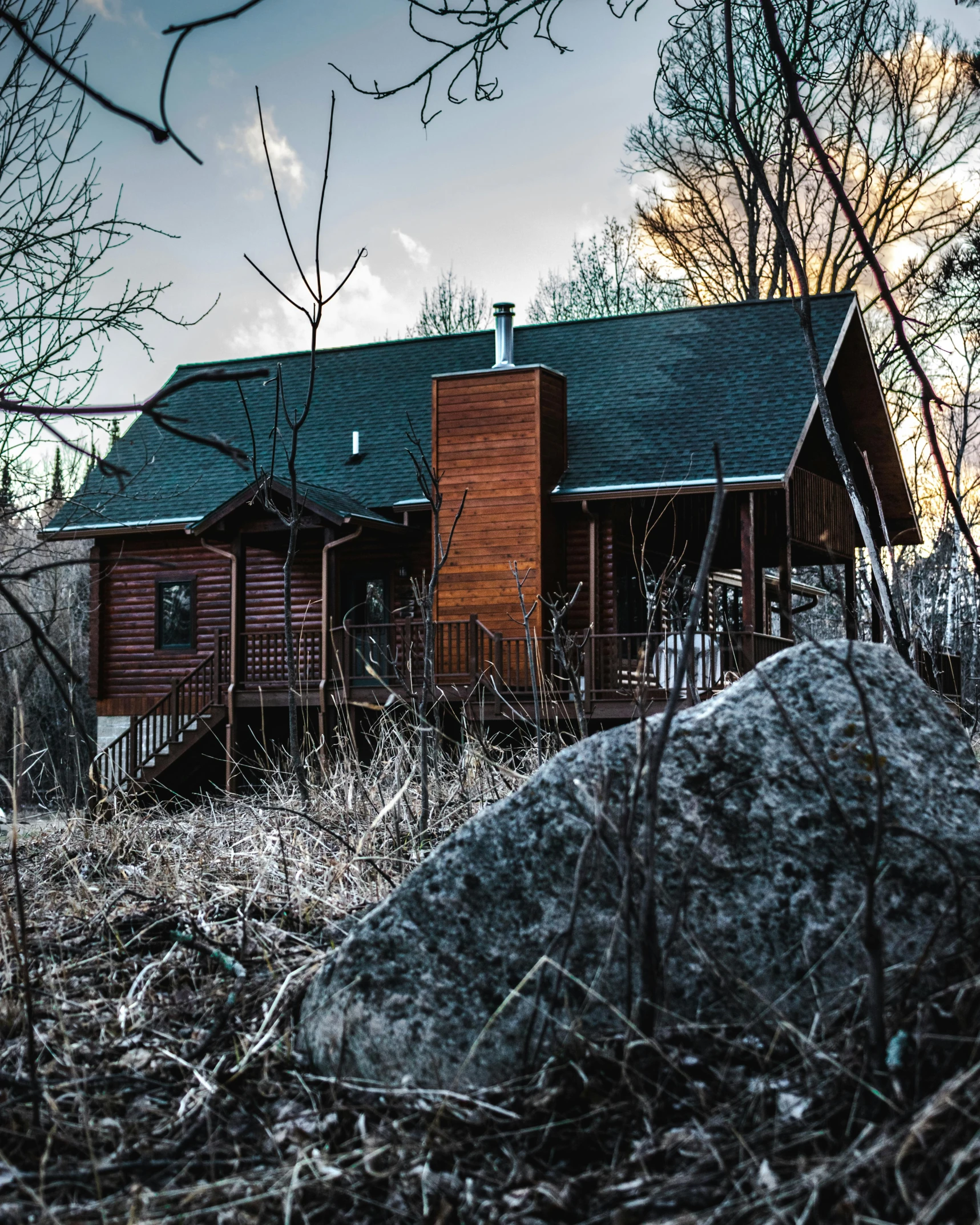 an old log cabin sits in a field next to some trees