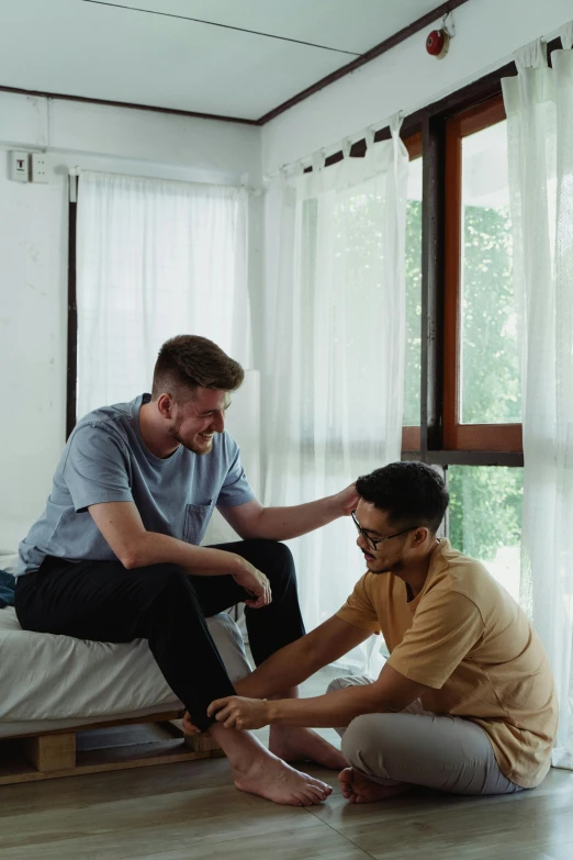 a couple of men sitting on top of a bed