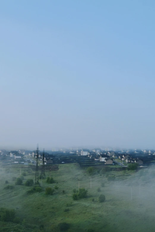 a lush green field covered in a lot of mist