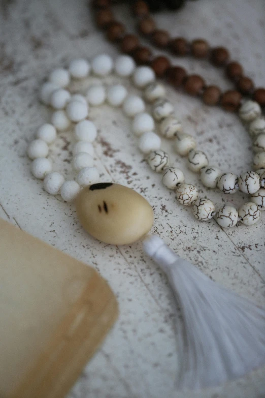 beads of white marbles, with one on a bead and a tassel