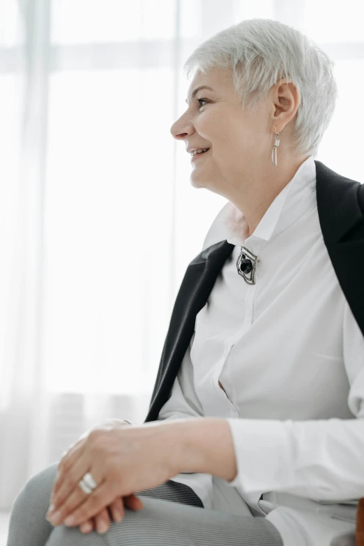 a woman sitting next to an empty window in front of a window