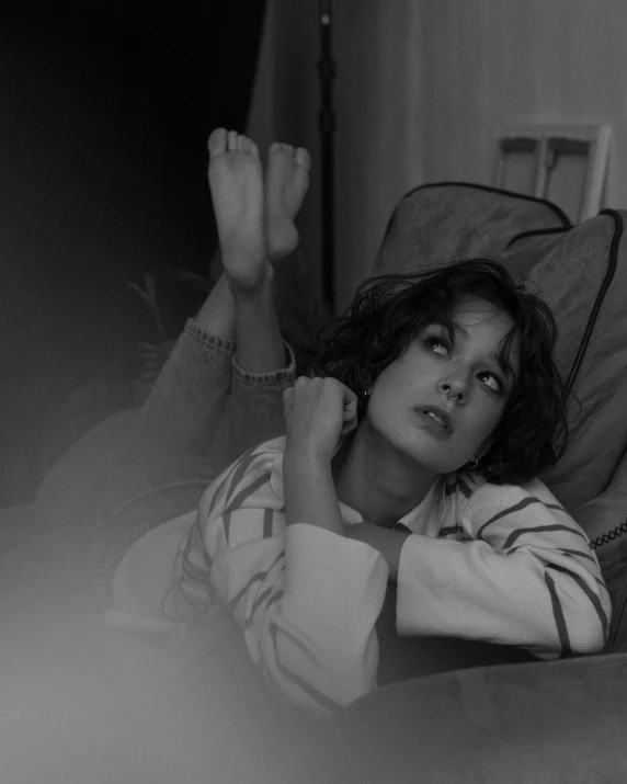 black and white po of young woman sitting in bed