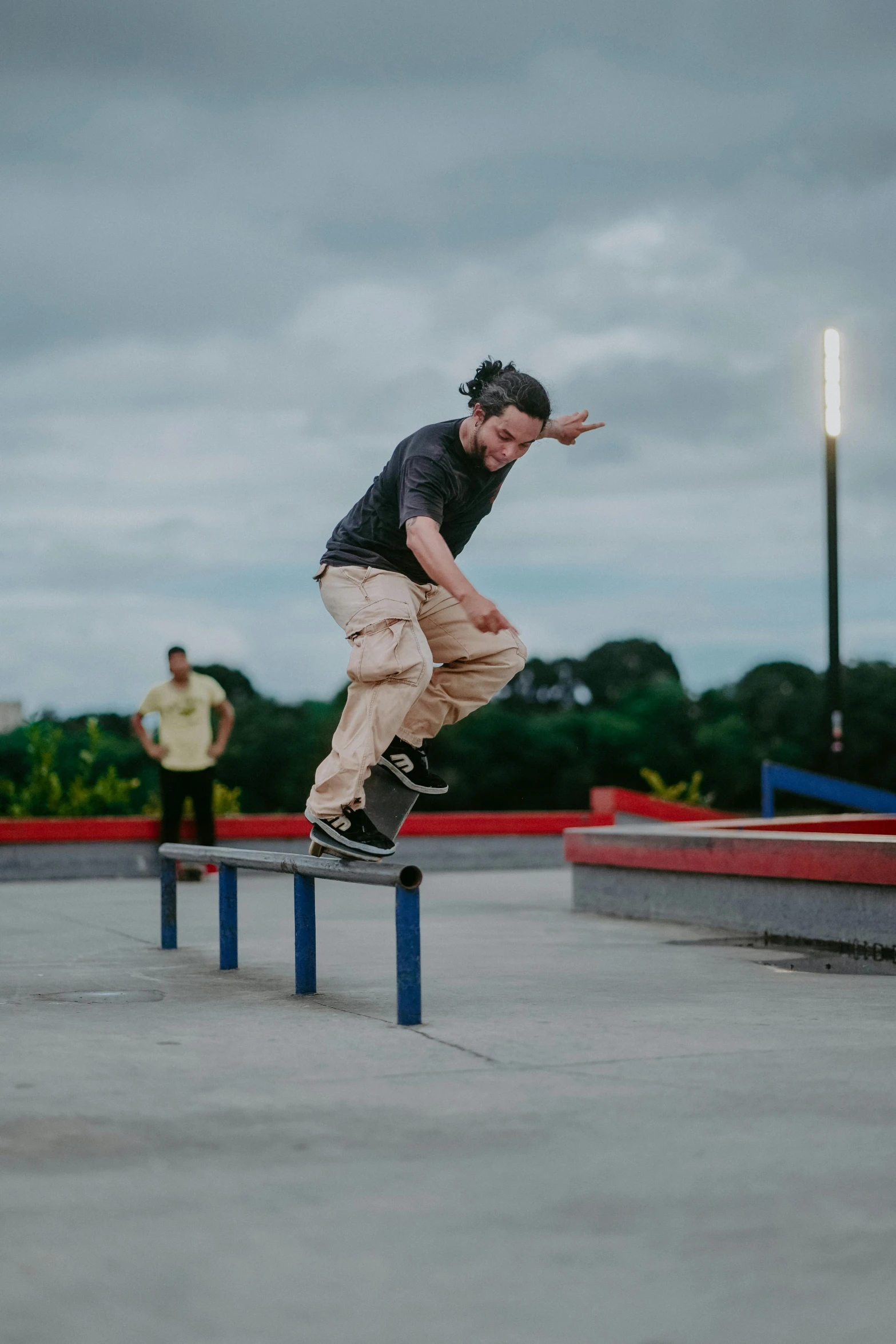 a boy is jumping a rail on a skateboard