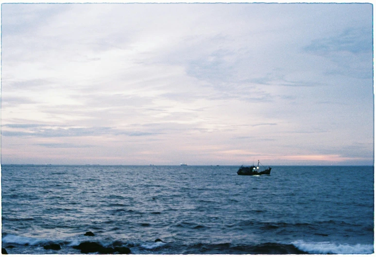 a boat in the water by a shore line