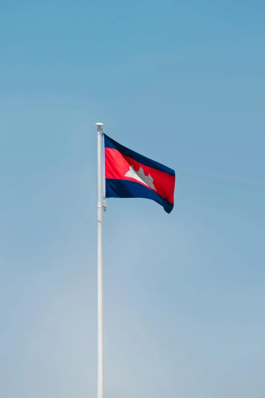 a large flag waving in the wind at an intersection