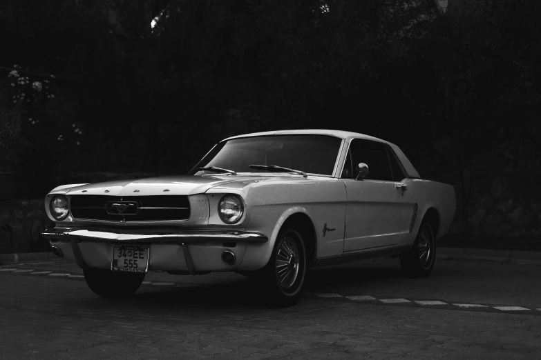 the mustang is parked near the wall in the parking lot