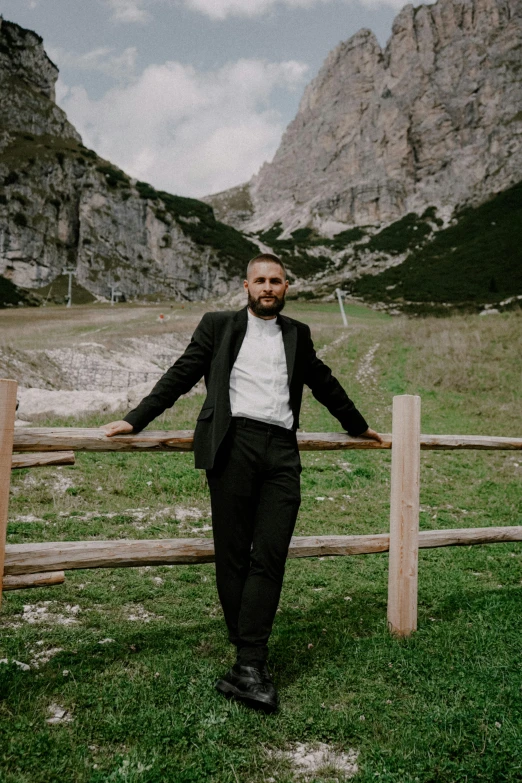 a man is standing near a fence on grass