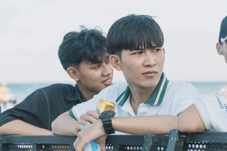 two men standing behind a railing next to each other