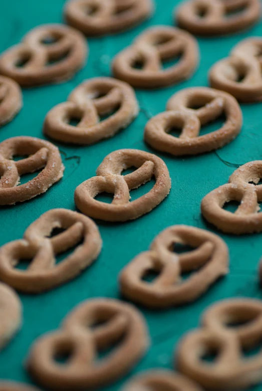 round brown pretzels sit on a green surface