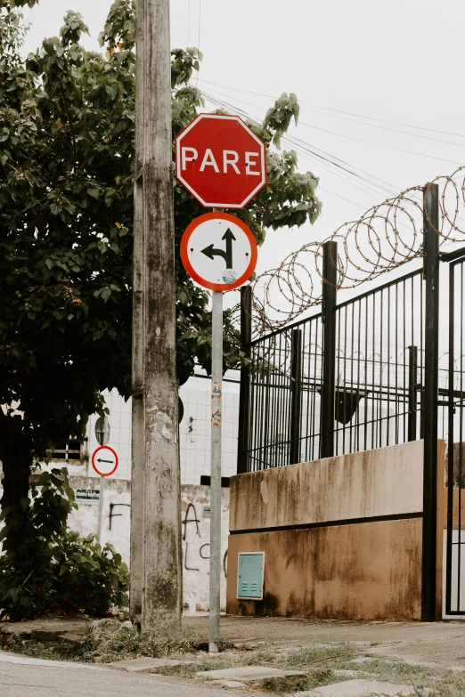 a red stop sign in front of a metal fence