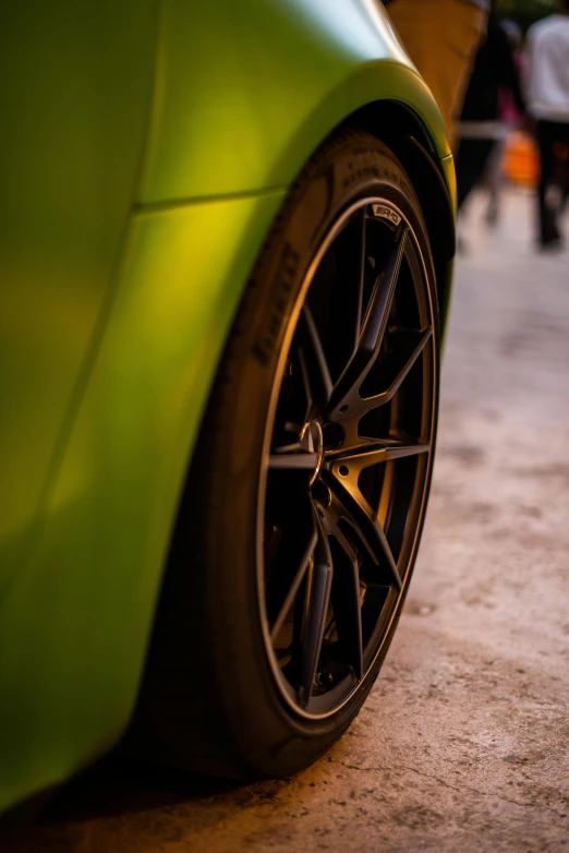 a close up po of a green sport car tire