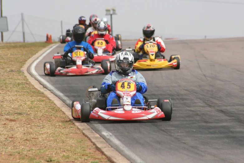 several people driving down a race track in bumper cars