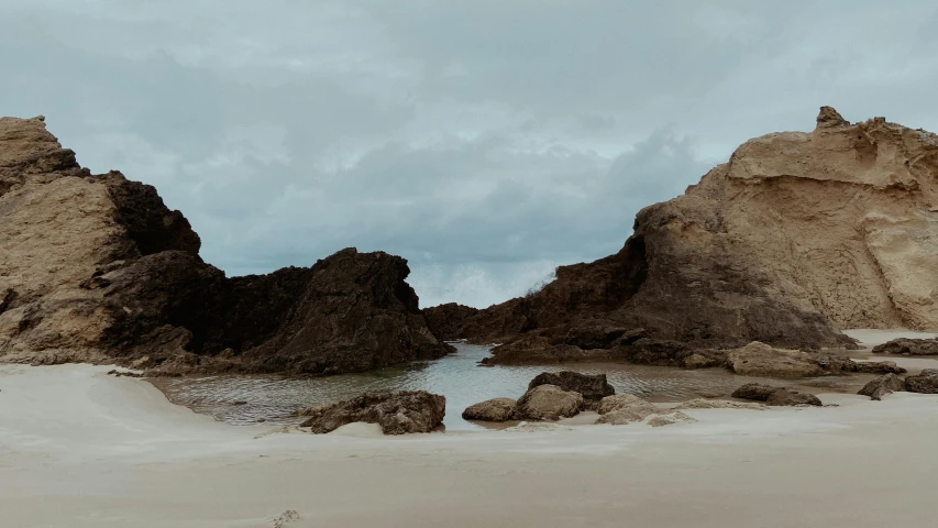 some very pretty rocks by the beach with water