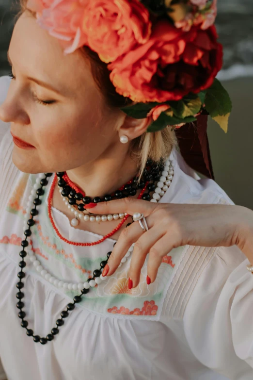 woman in a white blouse with beads and flower decoration