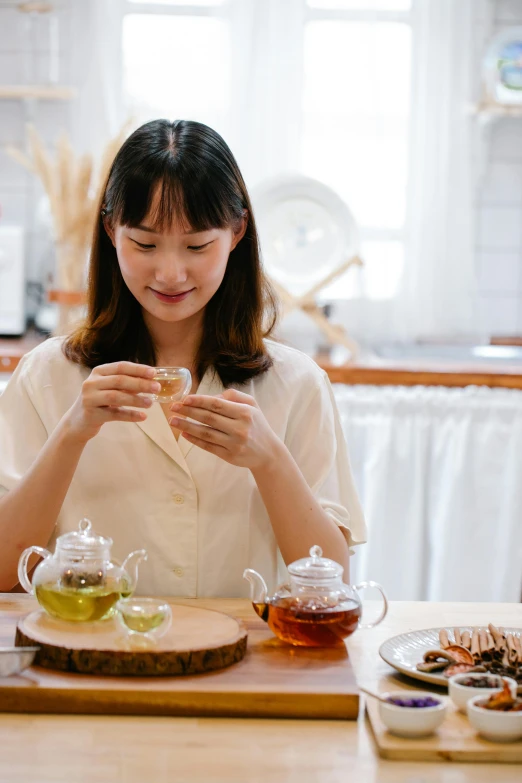 a woman sits at a table and plays with her cell phone