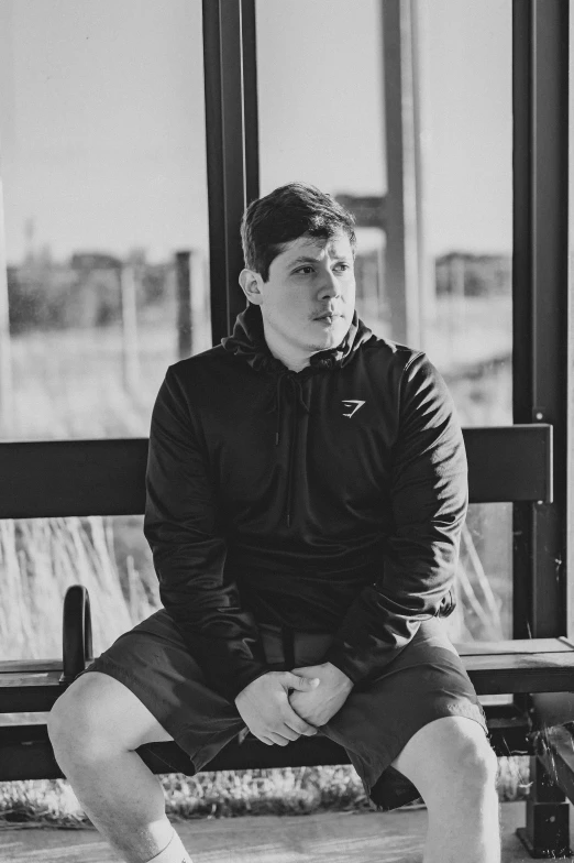 a man sitting on a bench, black and white