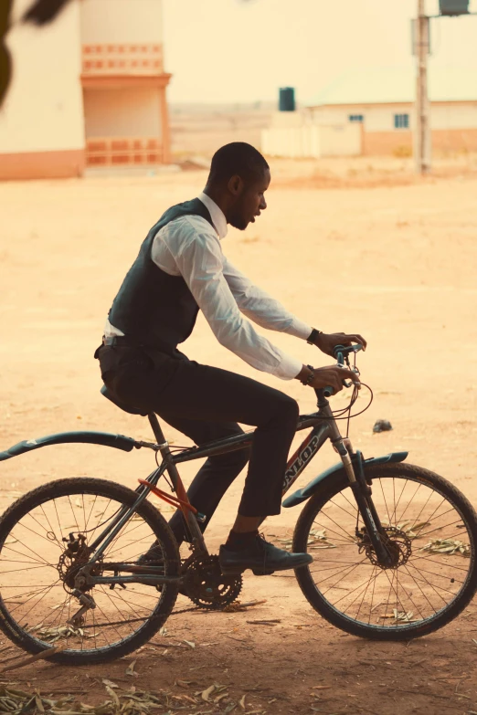 a man riding his bicycle across the dirt