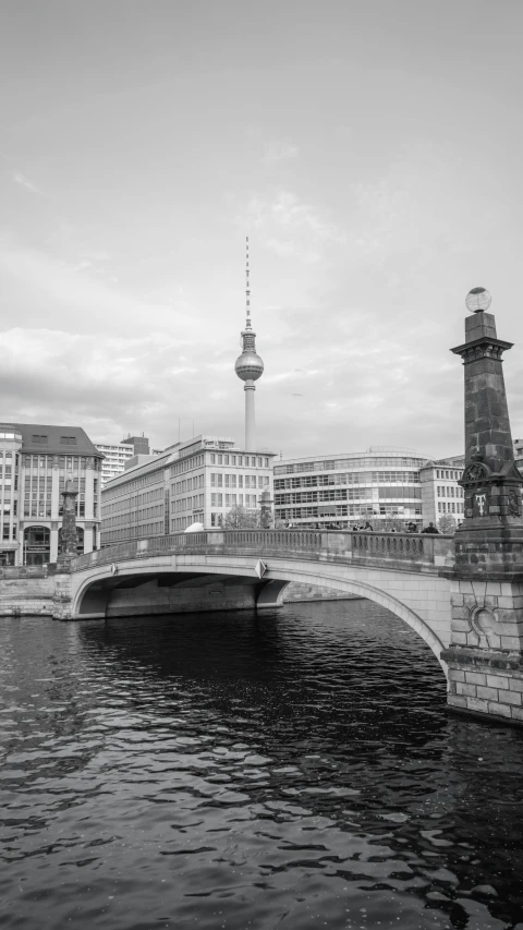 black and white pograph of bridge and water near buildings