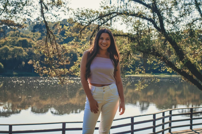 a girl posing for a pograph in front of a river