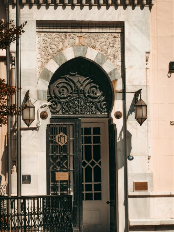 a white building has ornate windows and a black gate