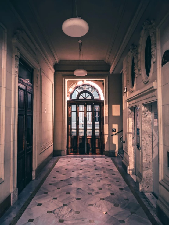 a hallway with doors and ornate decor with arched window