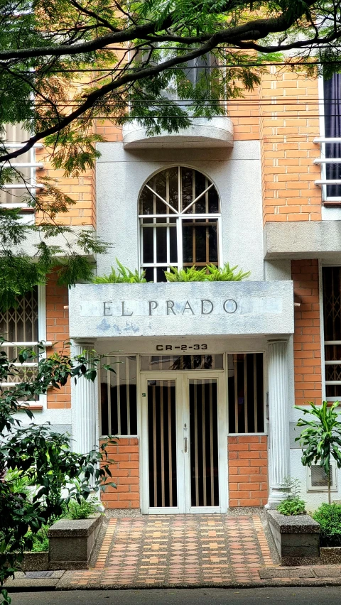 the entrance to a building with trees and shrubs