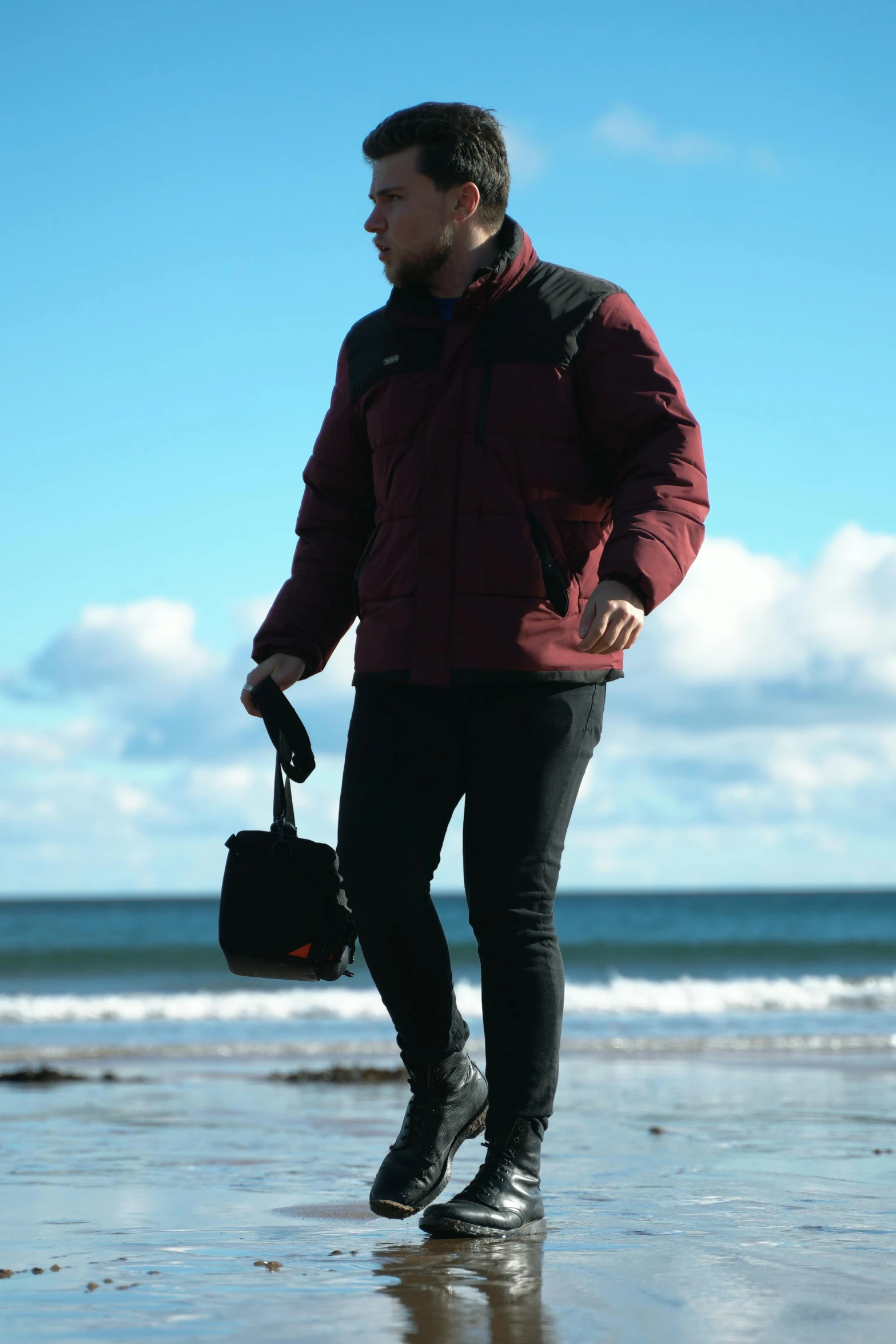 a man standing on the beach while holding a case