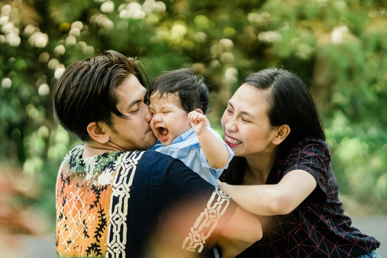 two adults and one child are posing for a family picture