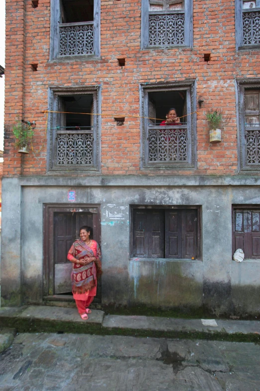 a woman standing at a doorway in front of a building