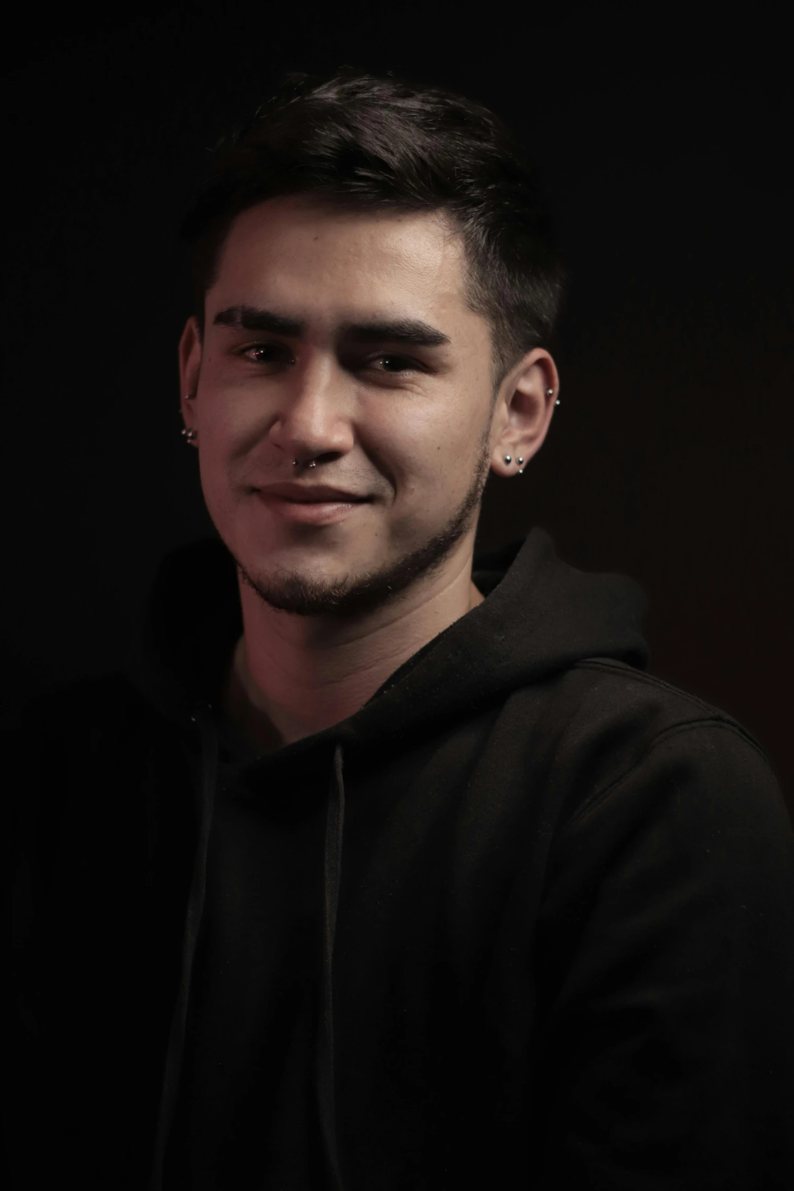 a male with a black shirt and ear piercings