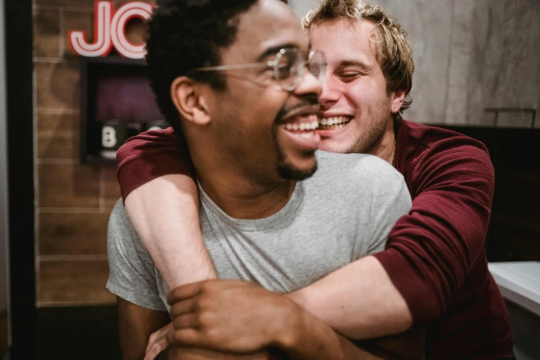 two young men smiling and emcing while sitting down