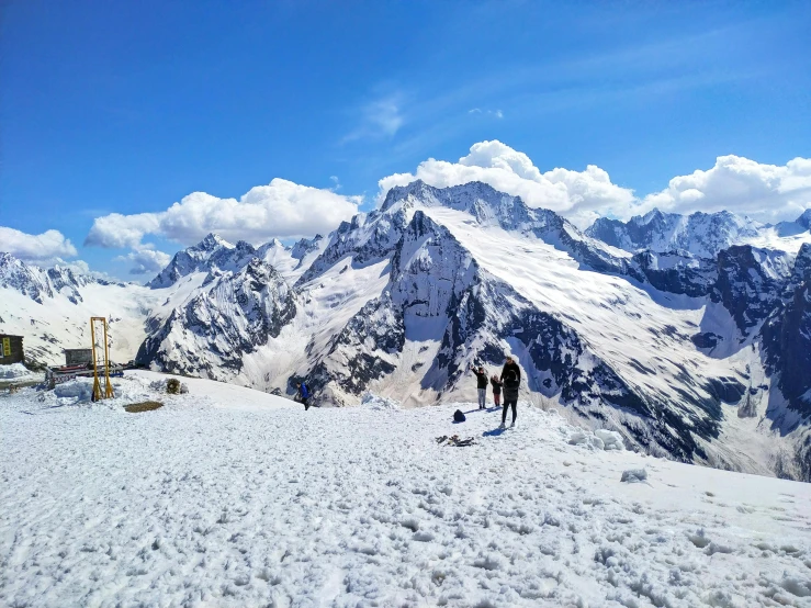 a couple of people standing on top of a snow covered slope