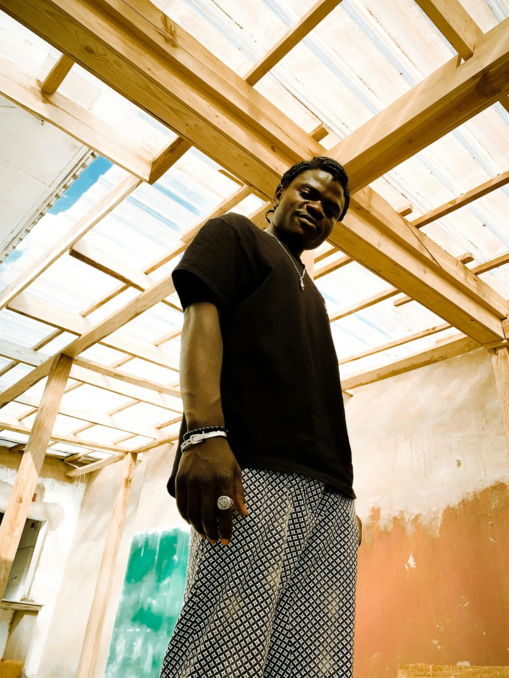 a young man standing under a wooden roof