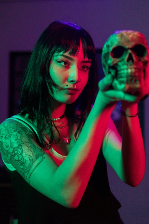 a beautiful woman holding a lit up skull in her hand