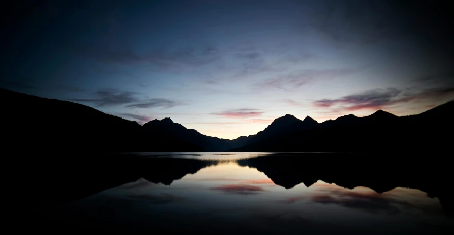 mountains against a twilight sky near a body of water