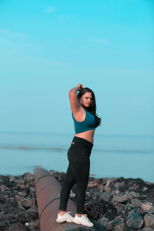 a beautiful young lady standing on top of a wooden pole