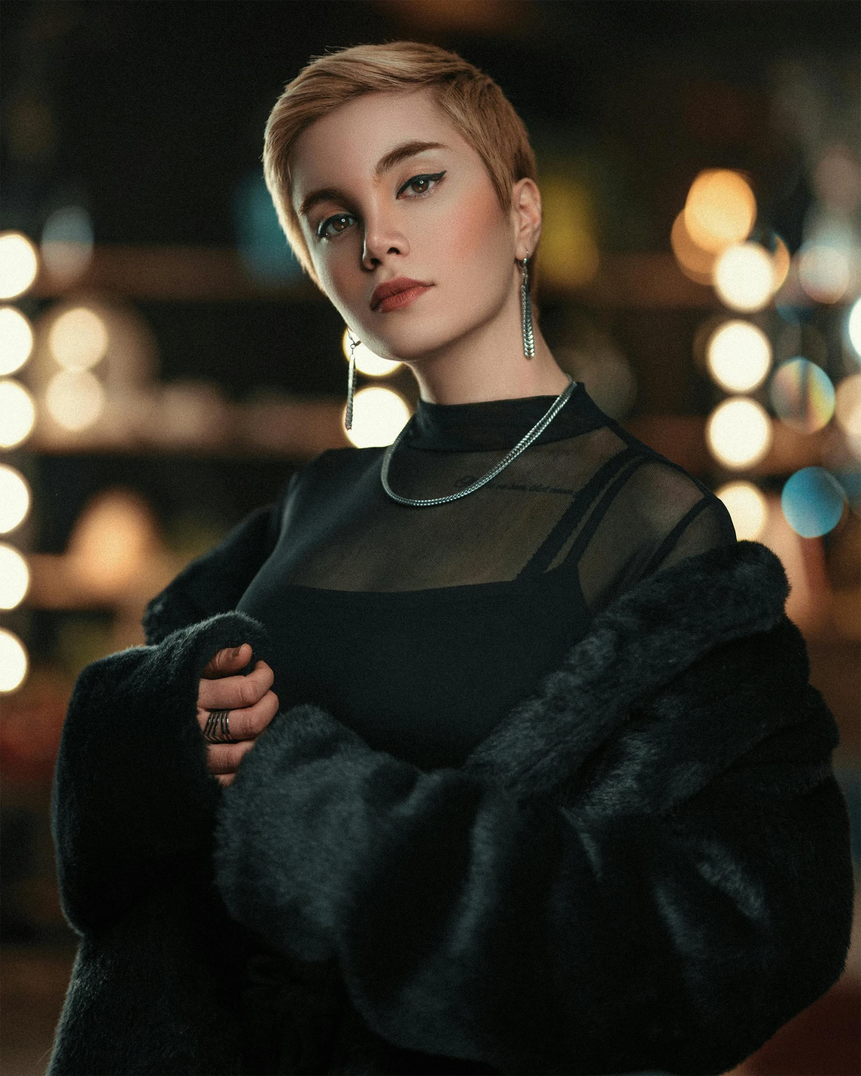 an elegant woman posing for a po while wearing an oversize coat