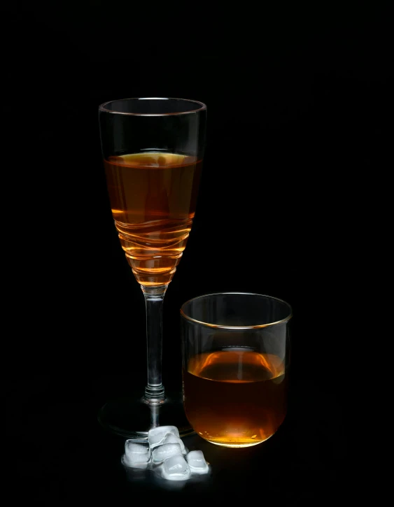 a glass with liquid and ice on the table