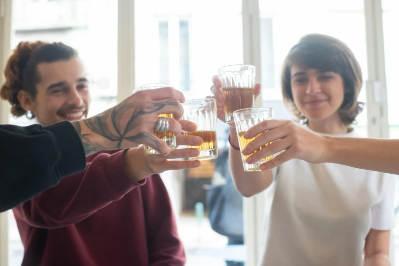 two women are toasting with drinks in front of other ladies