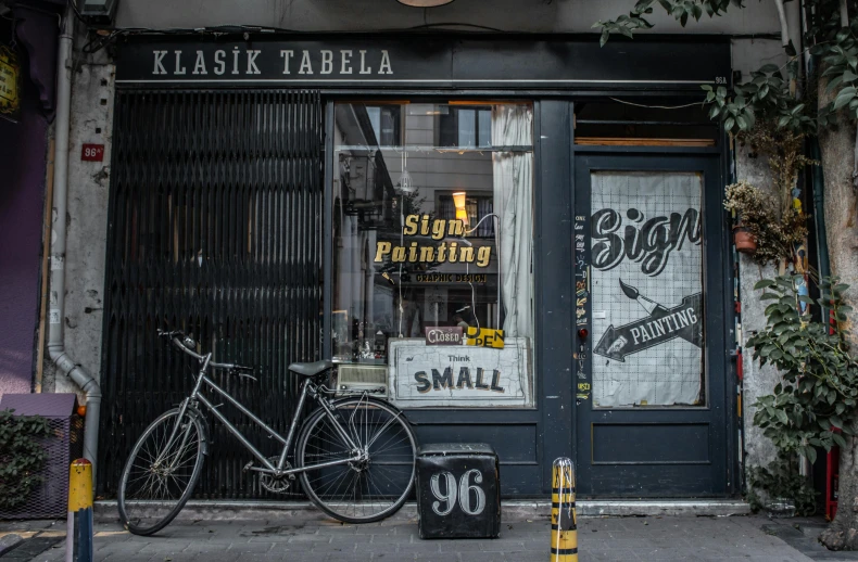 the storefront is decorated in all black and features a bicycle in front