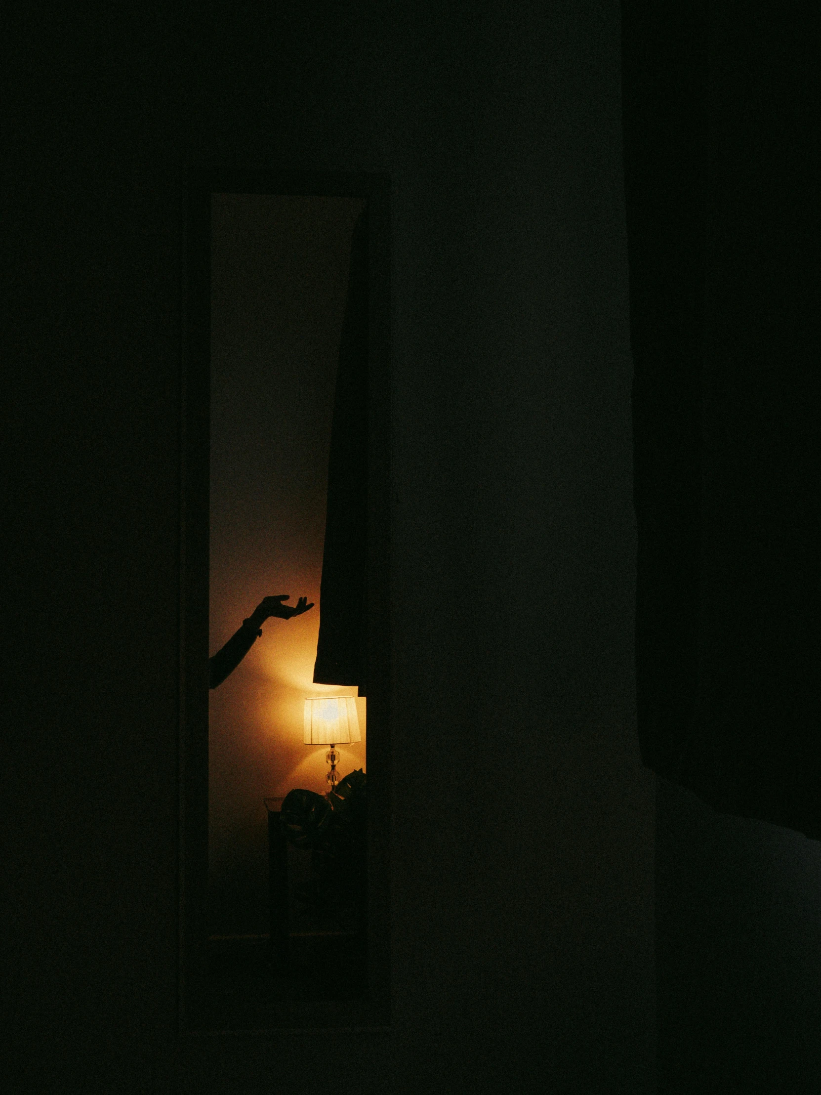 a person standing in front of a lamp in the dark