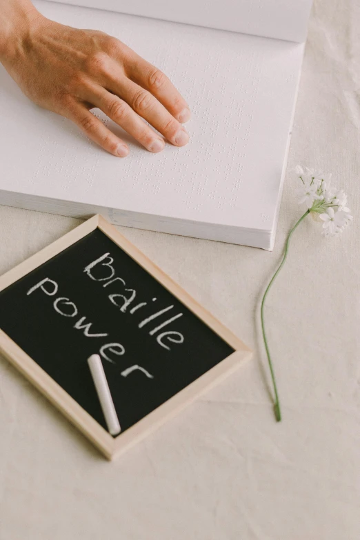 someone with their hand near a blackboard with words