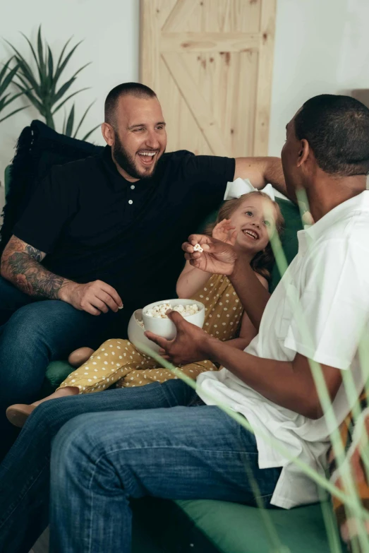 three men are laughing at one another as they sit down