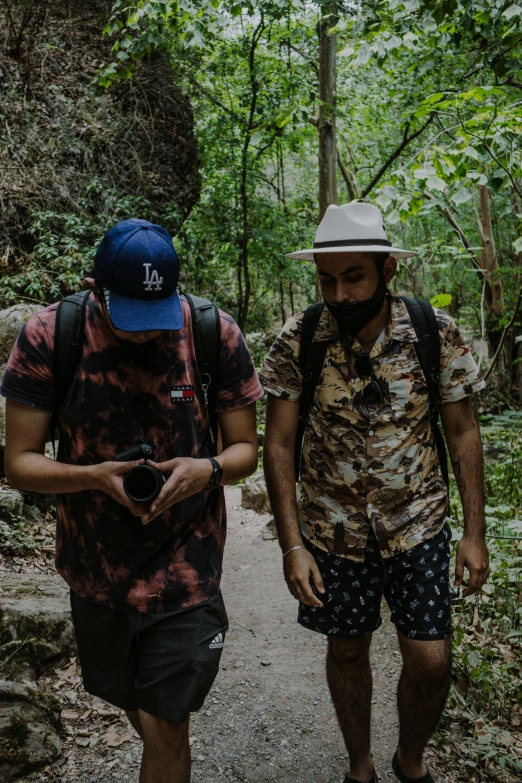 two men walking on a path in the woods