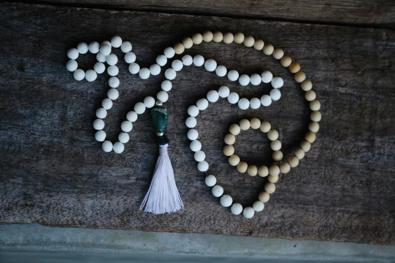 a string of white beads with a tassel in the middle