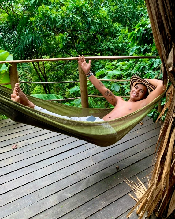 man relaxing in hammock on deck in jungle