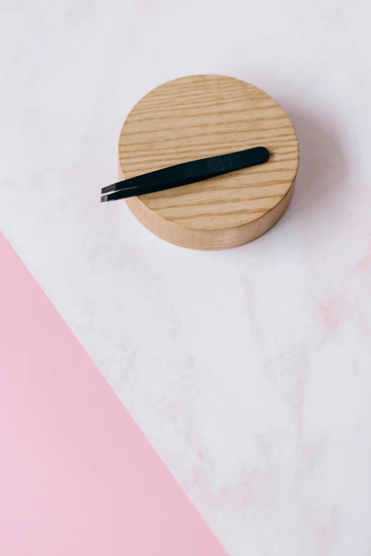 a round piece of wood with black sticks laying on top of it