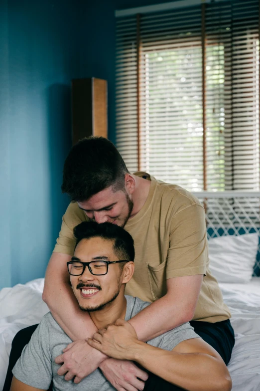 man sitting on man's back with hand on chest