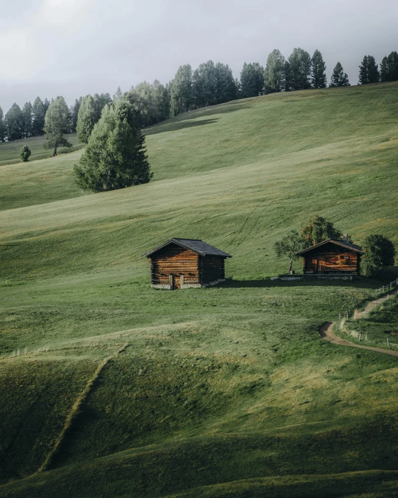 two barns are shown in a grassy field