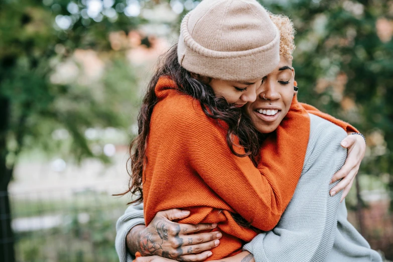 the woman is hugging the man in the park